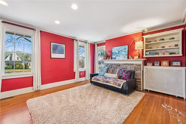 living area featuring visible vents, baseboards, radiator, and hardwood / wood-style flooring