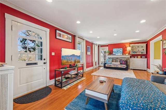 living area with crown molding, recessed lighting, wood finished floors, and baseboards