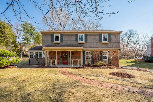 view of front of property featuring brick siding, covered porch, and a front yard