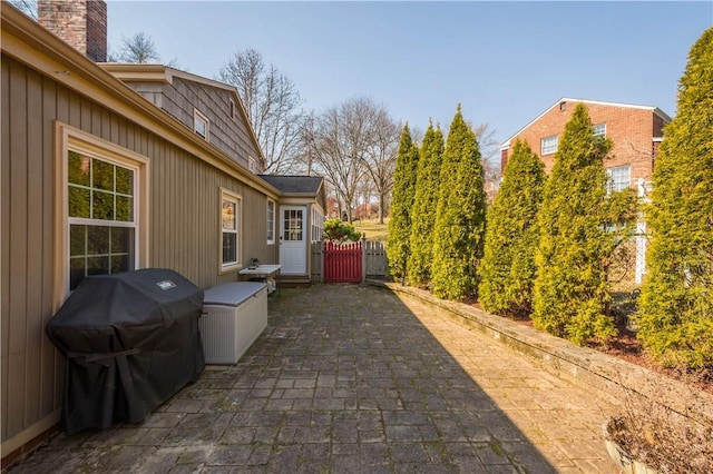 view of patio / terrace featuring area for grilling, fence, and a gate