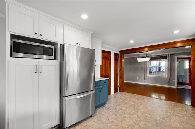 kitchen featuring recessed lighting, stainless steel appliances, white cabinets, crown molding, and blue cabinets