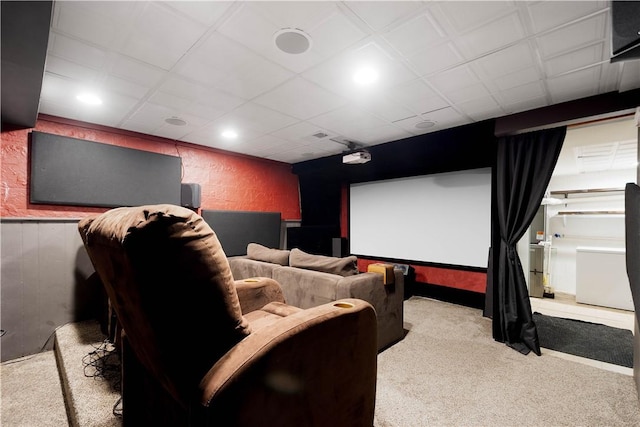 carpeted home theater with wainscoting and a textured wall