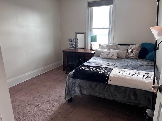 bedroom featuring baseboards and carpet