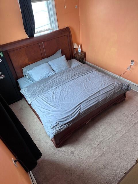 bedroom featuring baseboards and carpet