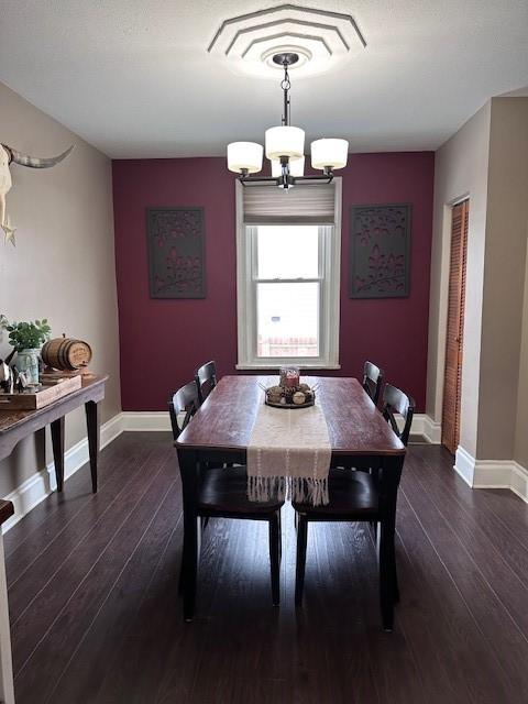 dining room featuring an inviting chandelier, baseboards, and wood-type flooring