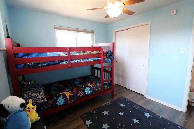 bedroom with a closet, a ceiling fan, baseboards, and wood finished floors