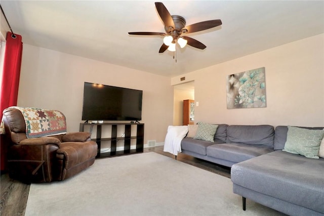 living area featuring visible vents, baseboards, and ceiling fan