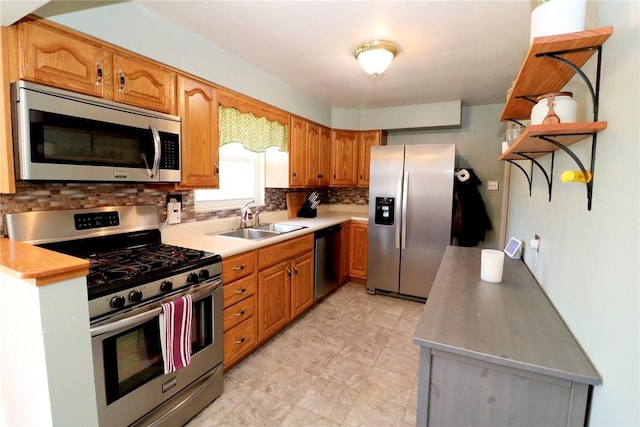 kitchen featuring a sink, light countertops, backsplash, and stainless steel appliances