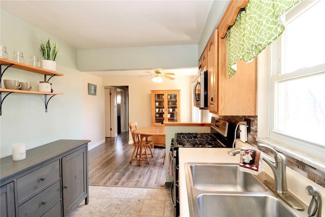 kitchen with open shelves, a sink, gray cabinetry, ceiling fan, and stainless steel appliances