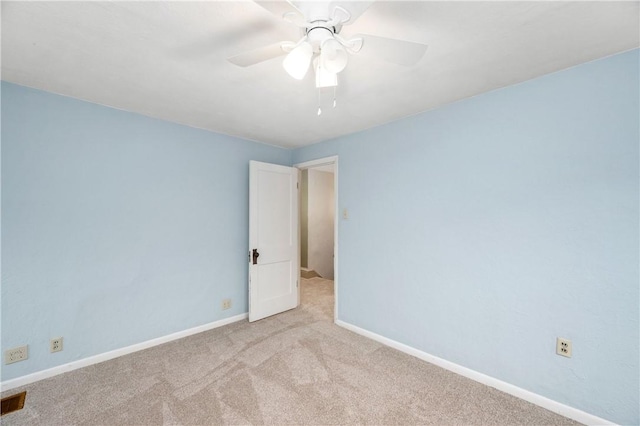 spare room with a ceiling fan, carpet, and baseboards