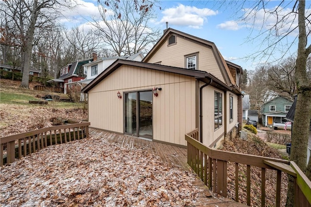 back of property featuring a gambrel roof and a deck