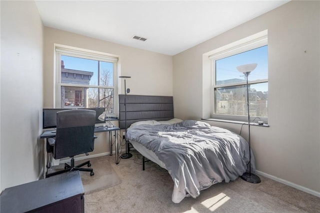 bedroom featuring visible vents, baseboards, and carpet