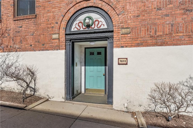 view of exterior entry with brick siding