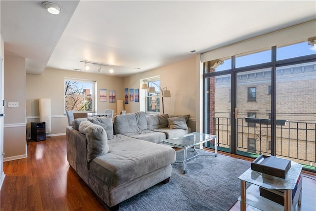 living area with baseboards and wood finished floors