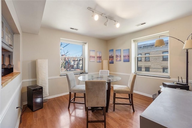 dining area featuring wood finished floors, visible vents, and baseboards