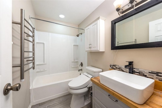 bathroom with backsplash, toilet, shower / tub combination, wood finished floors, and vanity