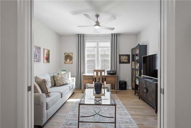 living room featuring ceiling fan and light wood finished floors