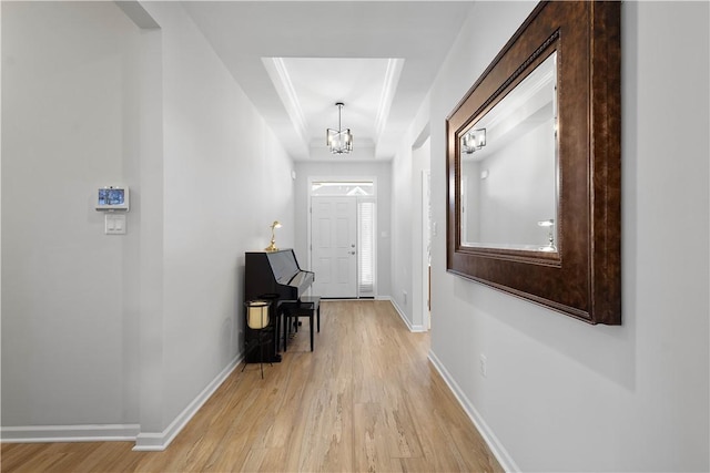 interior space with light wood finished floors, a notable chandelier, and baseboards