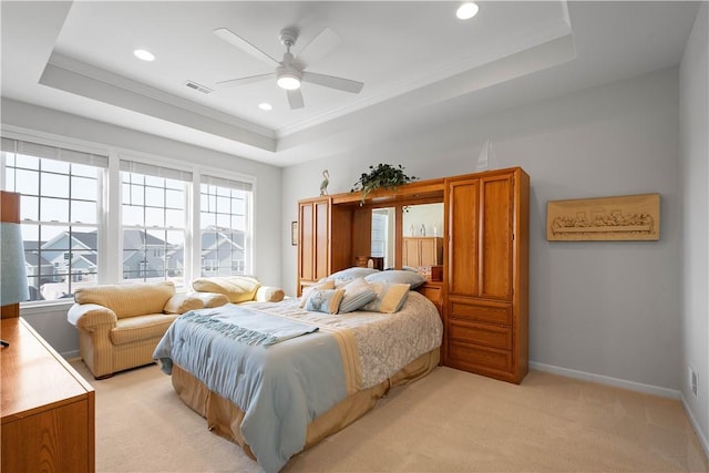 bedroom with visible vents, light colored carpet, baseboards, and a tray ceiling