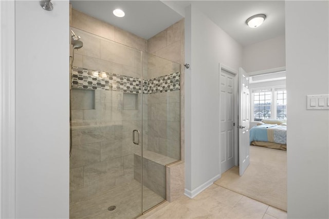 bathroom featuring tile patterned flooring, a shower stall, baseboards, and connected bathroom