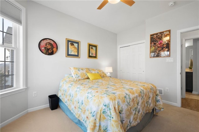 carpeted bedroom with a ceiling fan, visible vents, baseboards, and a closet