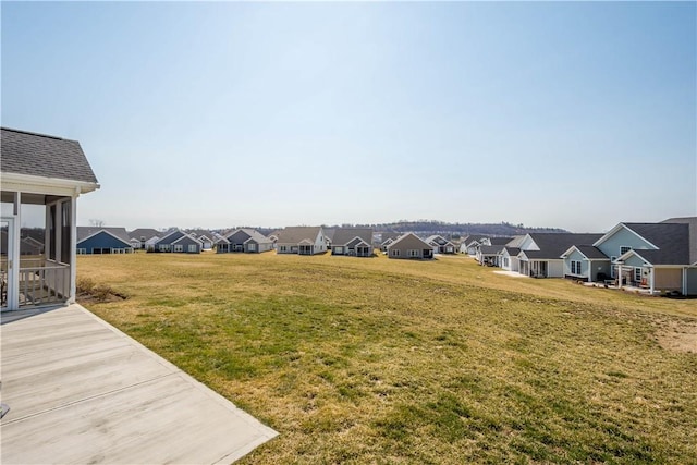 view of yard featuring a residential view and a sunroom