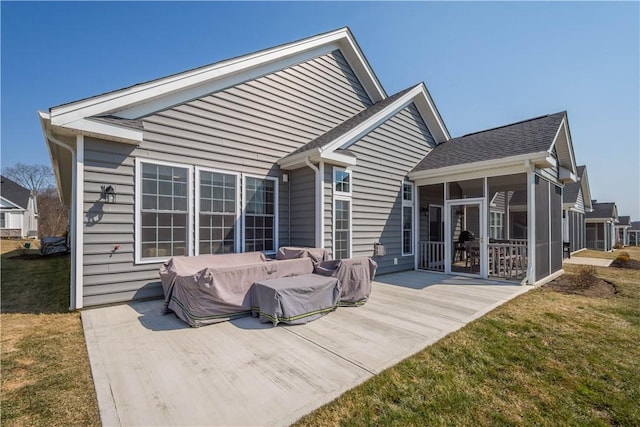 back of property with a lawn and a sunroom