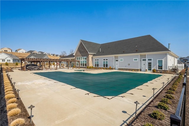 pool featuring a patio, fence, a pergola, and a residential view