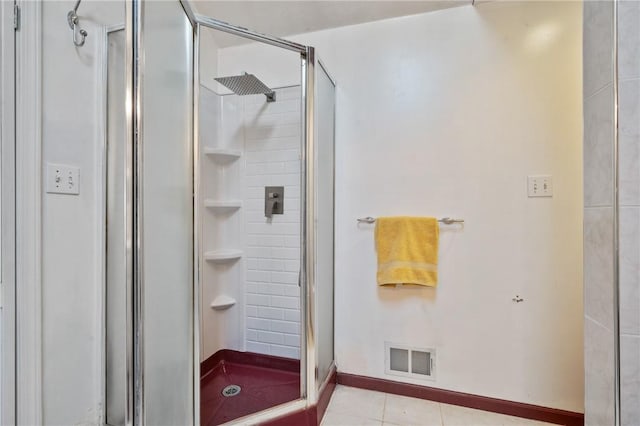 bathroom with a shower stall, baseboards, visible vents, and tile patterned floors