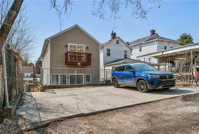 rear view of property with a gate, fence, and driveway