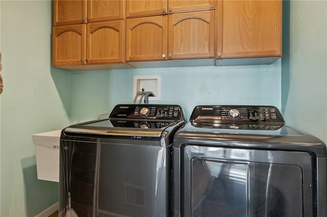 laundry room with washer and clothes dryer and cabinet space