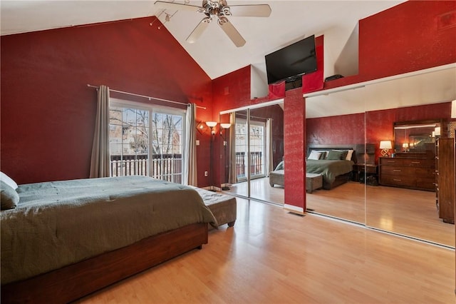 bedroom featuring access to exterior, high vaulted ceiling, a ceiling fan, and wood finished floors