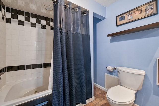 bathroom featuring stone finish flooring, baseboards, toilet, and shower / tub combo with curtain