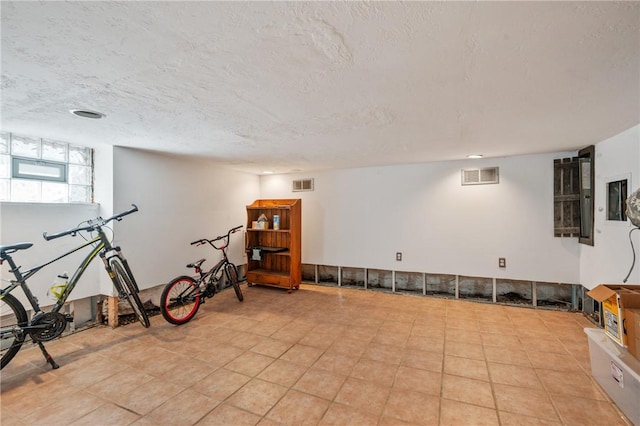 exercise area featuring visible vents and a textured ceiling