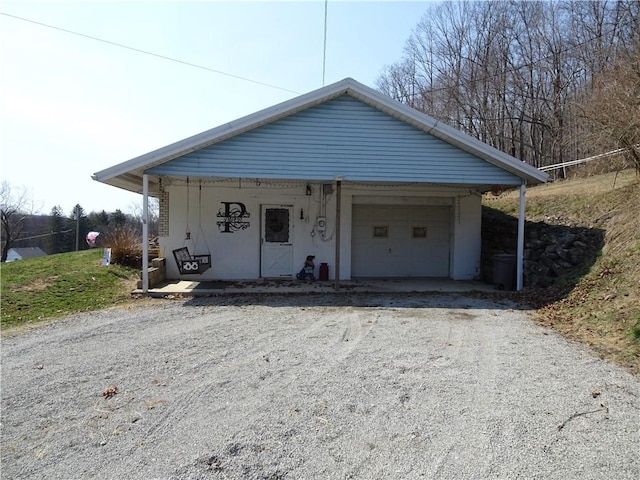 bungalow with a garage, covered porch, driveway, and stucco siding