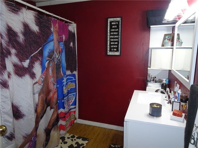 full bathroom with vanity, a shower with shower curtain, wood finished floors, and baseboards