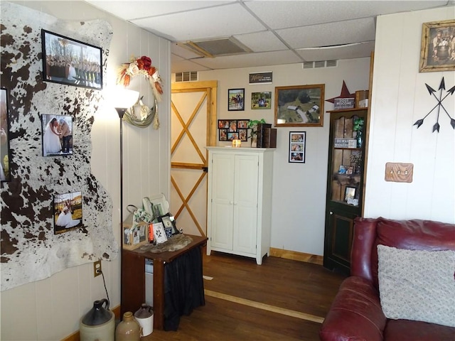 interior space featuring visible vents, a paneled ceiling, and dark wood-style flooring