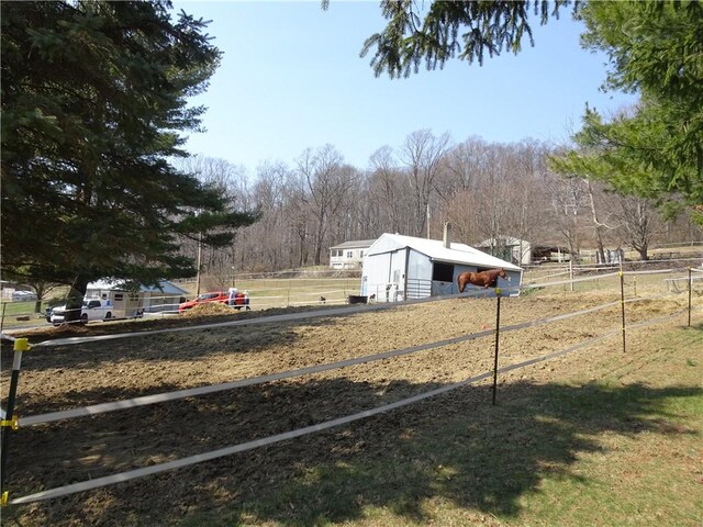 view of yard with an outbuilding, a rural view, and fence