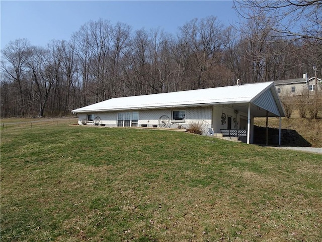 back of property with a carport and a lawn