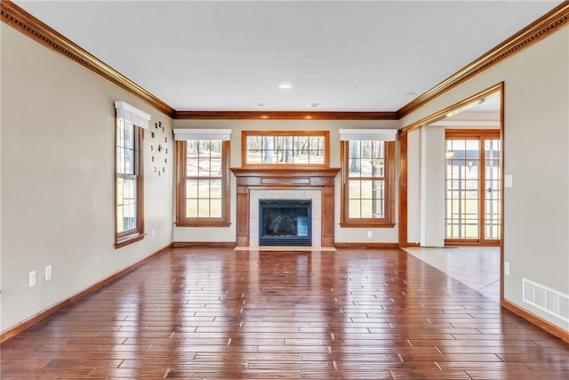 unfurnished living room with visible vents, dark wood finished floors, a fireplace, and crown molding