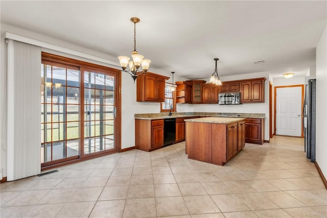 kitchen featuring brown cabinets, a notable chandelier, black appliances, and a center island