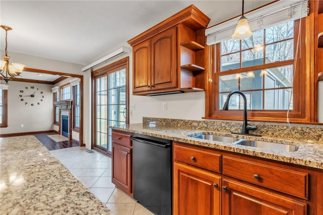 kitchen featuring dishwasher, light stone counters, light tile patterned floors, brown cabinetry, and a sink