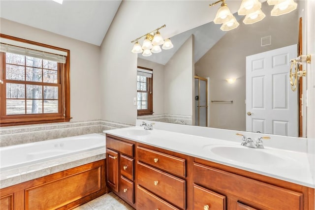 bathroom featuring a sink, visible vents, a bath, and vaulted ceiling