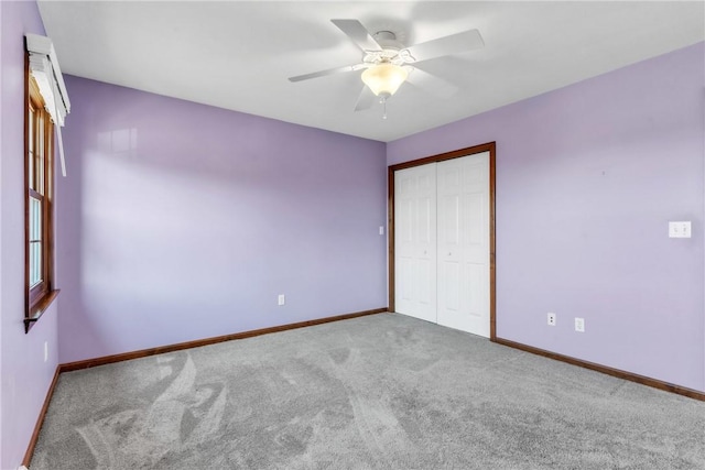 unfurnished bedroom with a closet, carpet flooring, ceiling fan, and baseboards