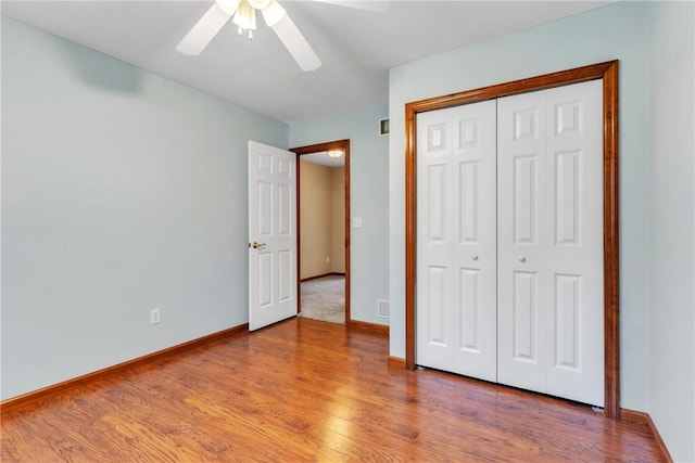 unfurnished bedroom featuring light wood-type flooring, baseboards, a closet, and ceiling fan