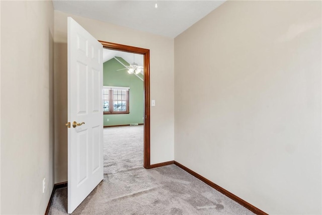 unfurnished room featuring light carpet, ceiling fan, lofted ceiling, and baseboards