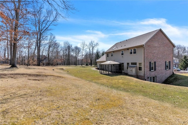 rear view of property featuring a gazebo and a yard