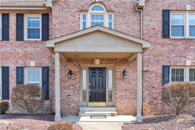 view of exterior entry featuring brick siding