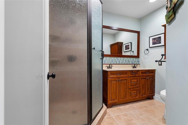 bathroom featuring double vanity, tasteful backsplash, a stall shower, and tile patterned floors