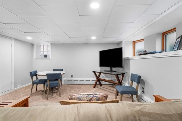 living room with a baseboard heating unit, carpet flooring, and baseboards